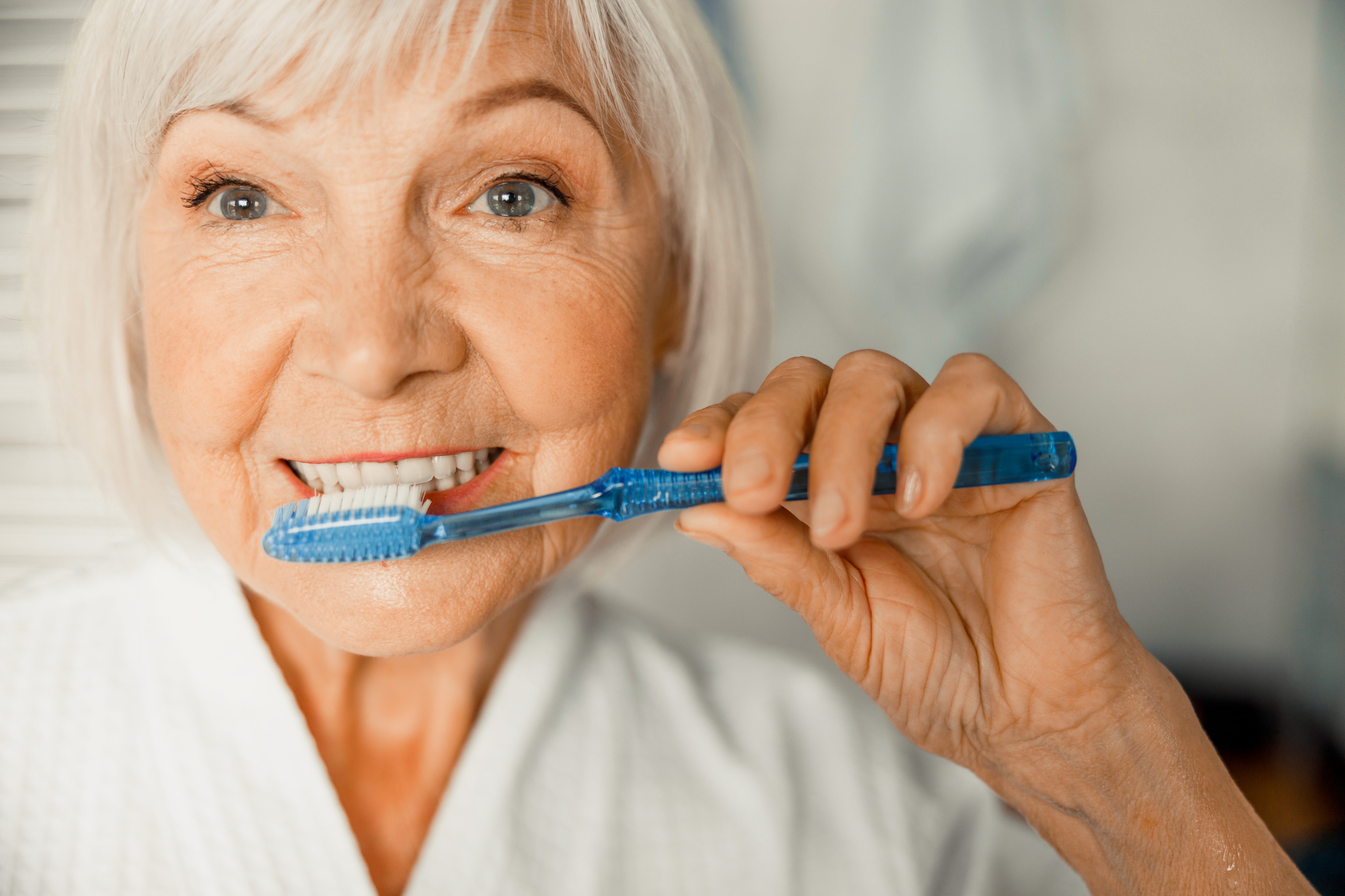 Old Woman Brushing her Teeth